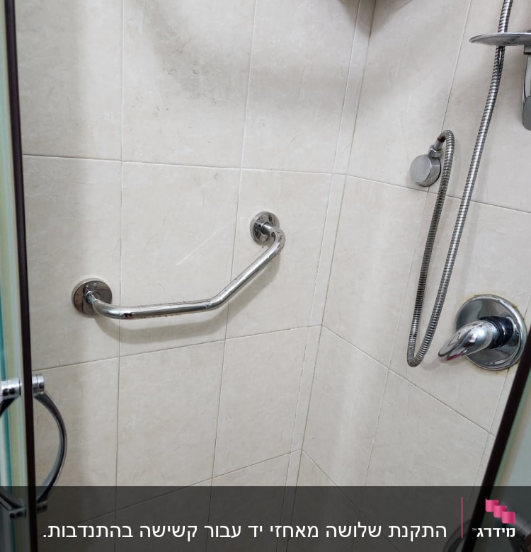 מקלחון עם ידית אחיזה מתכתית על הקיר